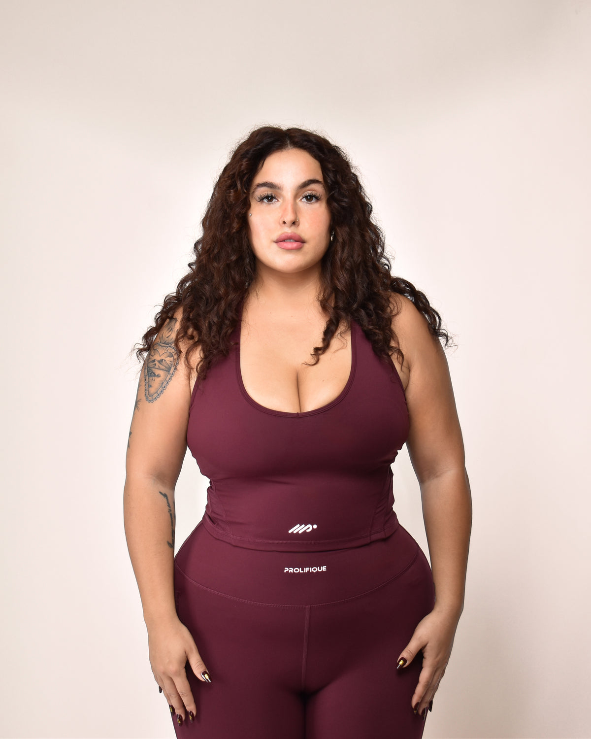 Woman wearing the EEVE Flex-Dry Racer Top in maroon with matching leggings | 165cm · size XL