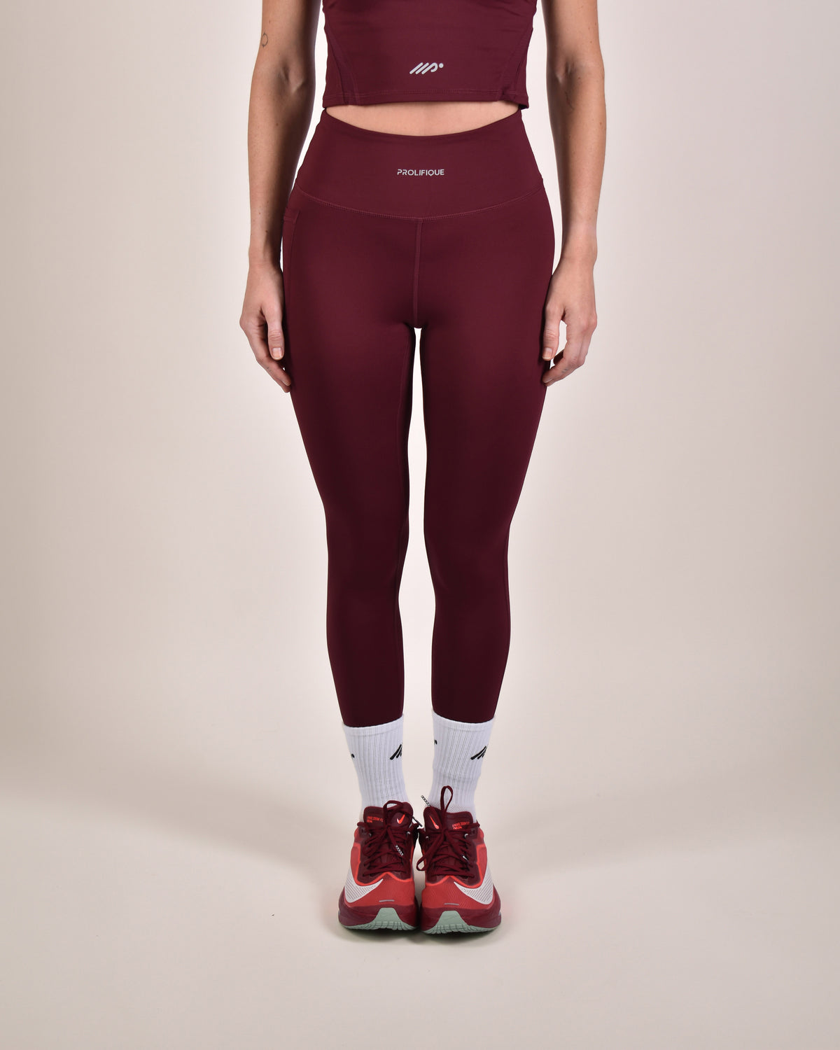 Woman wearing the NIMA Flex-Dry Leggings in maroon with matching top| 175 cm · size S